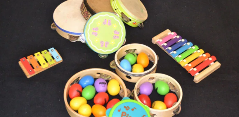 Instruments d'éveil musical posés sur un tapis : œufs sonores, tambourins et xylophone, lors d'un atelier d'éveil musical pour enfants